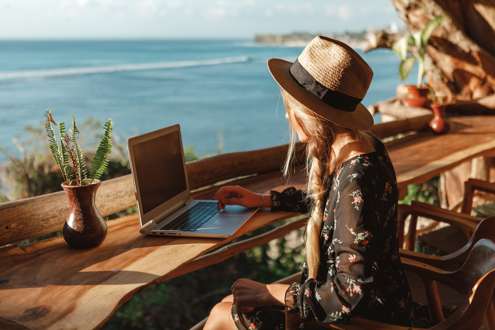 Business,Woman,Working,With,Computer,On,The,Beach.,Freelance,Concept. Woman Trading on a laptop
